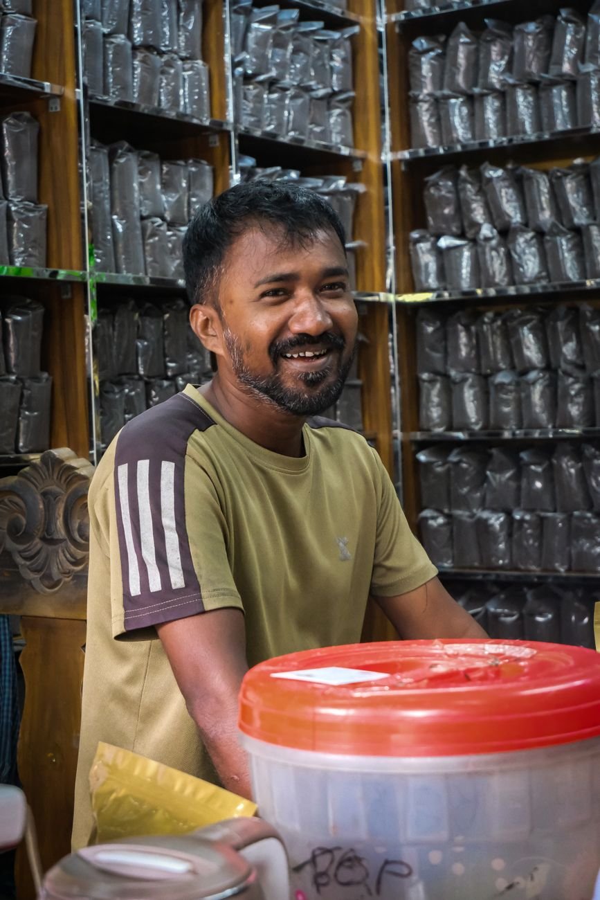 Friendly shopkeeper smiling in a tea store